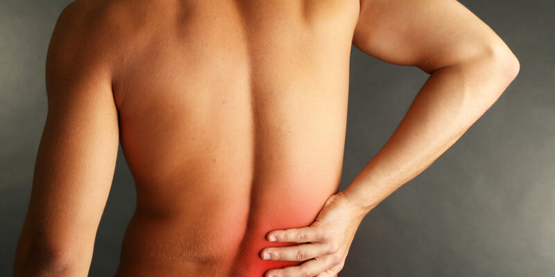 man holding lower back in pain